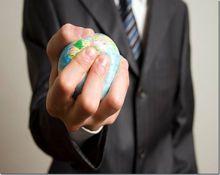 businessman squeezing the world in his hand